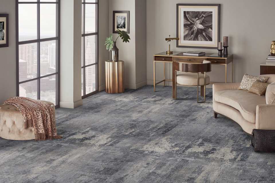 dark grey and blue patterned carpet in formal sitting room with gold accents and velvet furniture